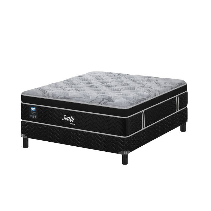 Juego de colchón y box Sealy Arona Queen Size en cama con funda y almohadas, vista lateral en habitación moderna.