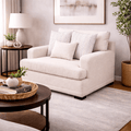 Sillón Oliver de cuero blanco con textura afelpada, respaldo y asiento acolchados, en un espacio moderno.